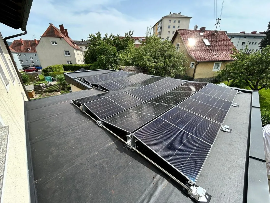 Aufgeständerte Photovoltaik-Module auf einem Flachdach im Wohngebiet