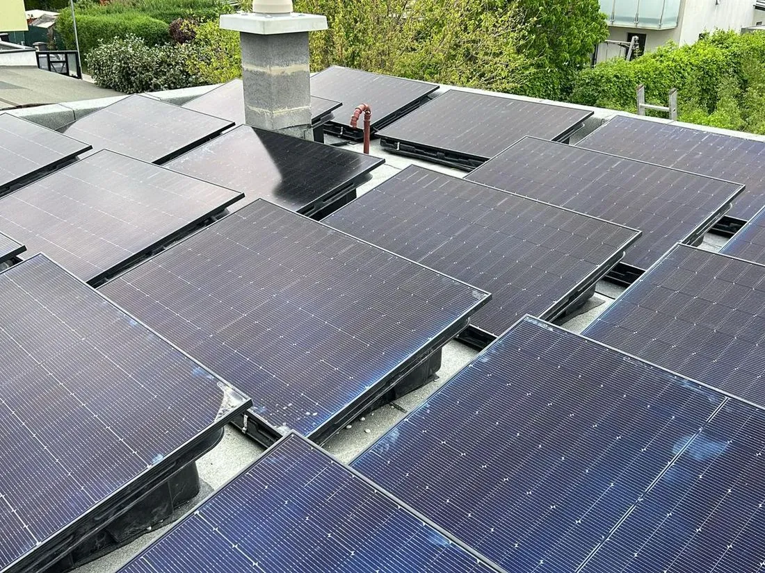 Photovoltaik-Module rund um den Kamin auf einem Flachdach in Wien