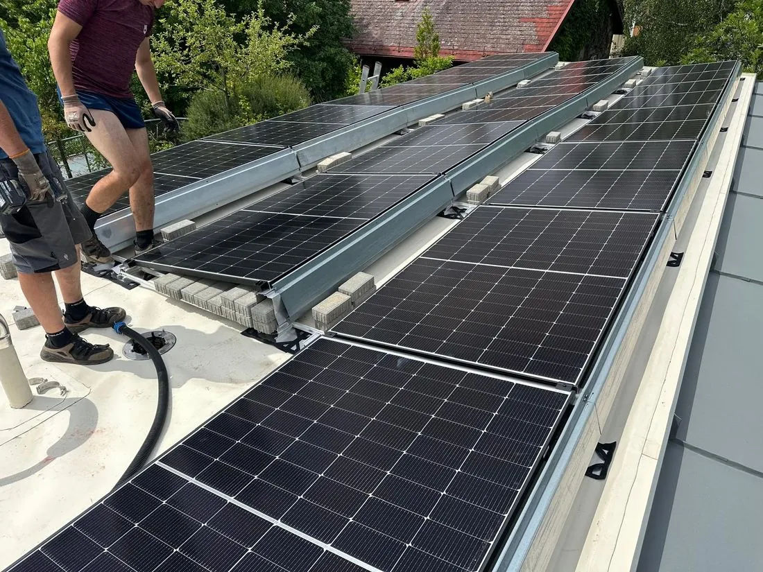 Monteur verlegt PV-Module auf einem Stehfalz-Metalldach in Niederösterreich