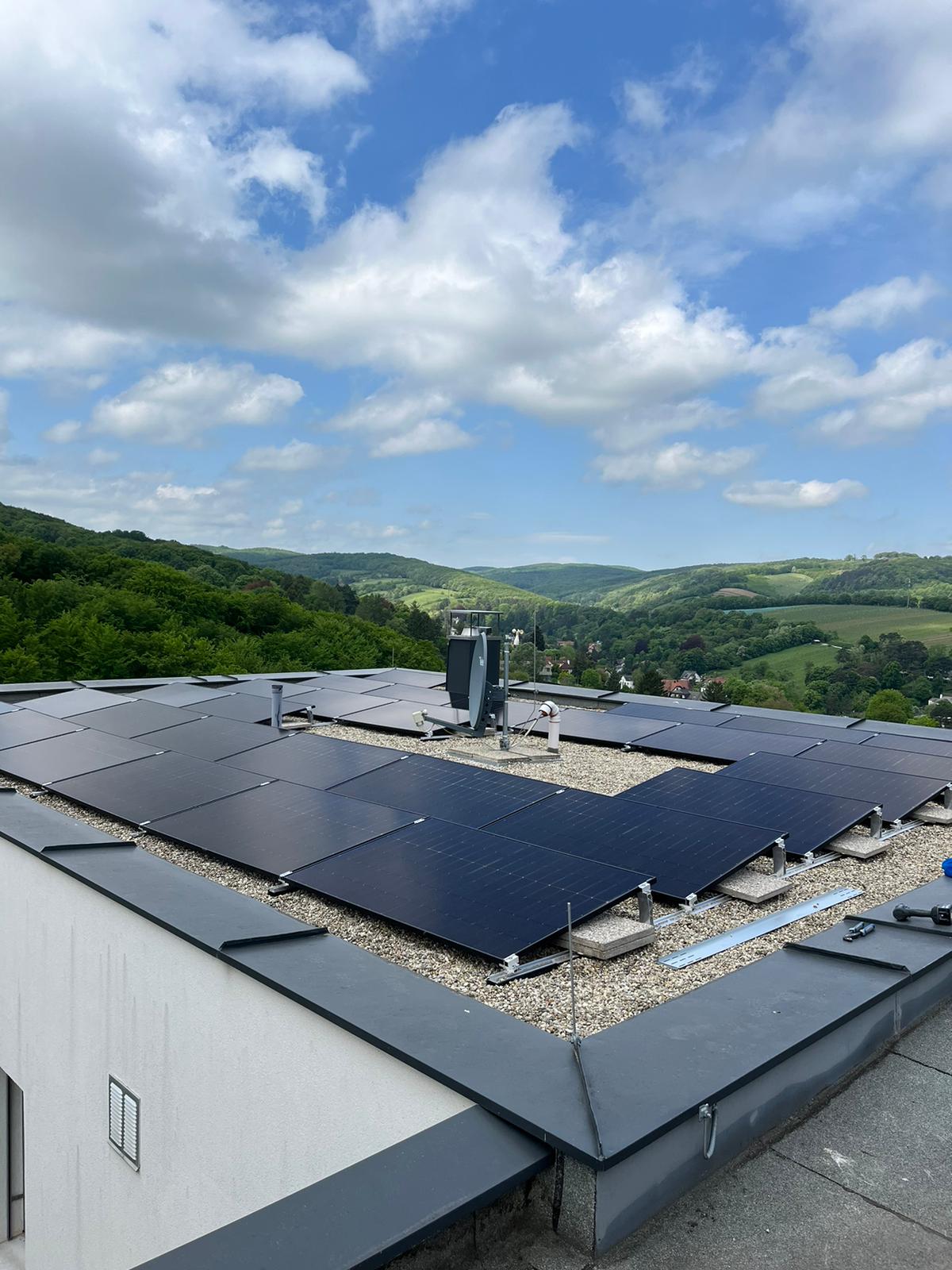 Photovoltaik Wien & NÖ – Elektro VolteX Photovoltaikanlage auf einem Flachdach mit Bergblick – Elektro VolteX, Wien & Niederösterreich
